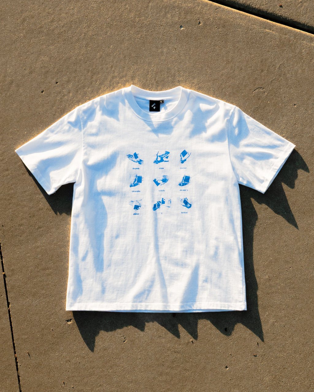 Get a Grip Tee flat lay on concrete