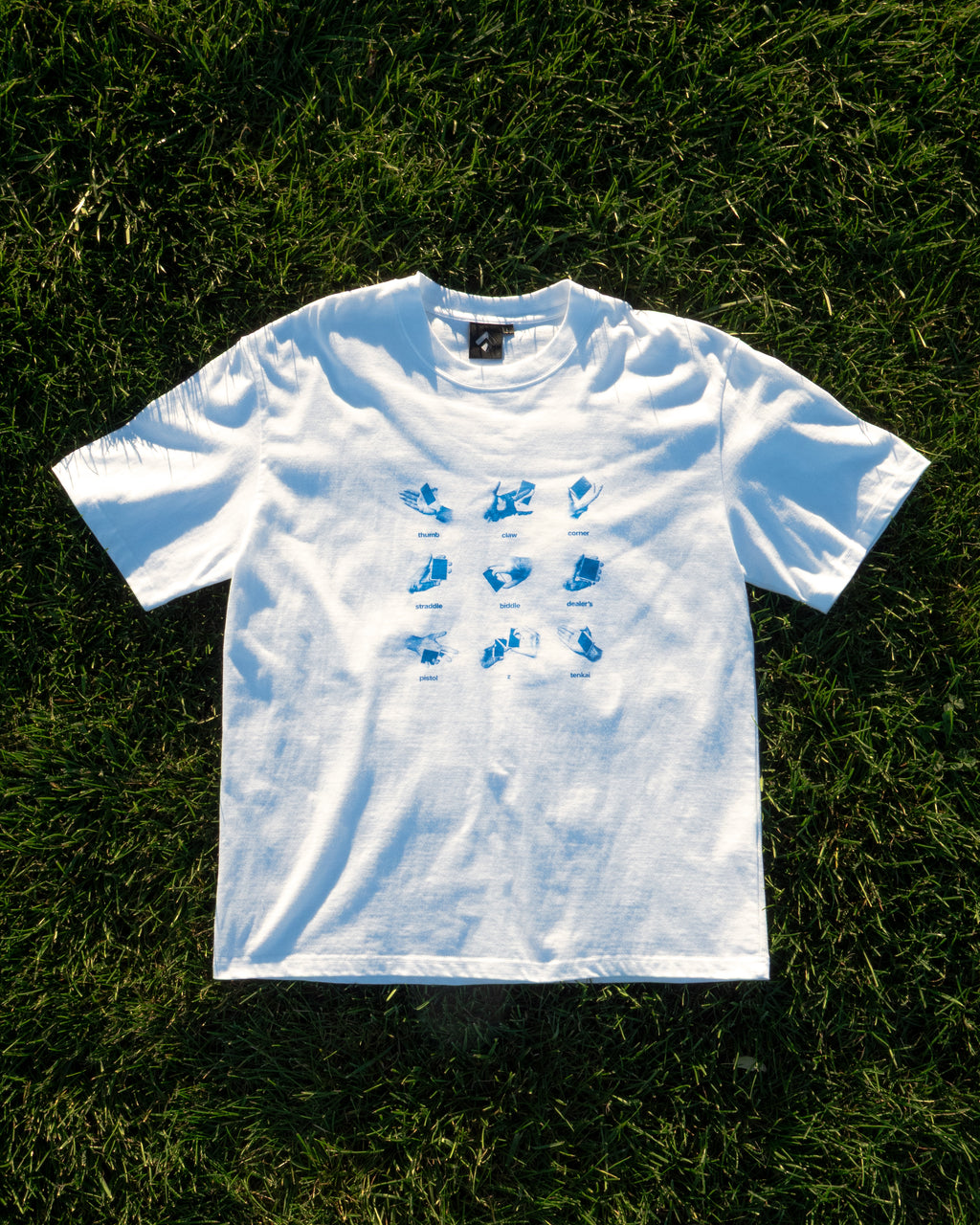 Get a Grip Tee flat lay on grass